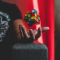 Rubik's Cube levitating over a hand with vibrant backdrop, creating a sense of whimsy and intrigue.