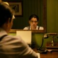 A vintage scene of a man reflecting in a mirror beside a classic telephone, creating a nostalgic atmosphere.