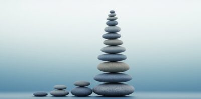 Stones stacked on top of each other represent the cumulative and compound effect.