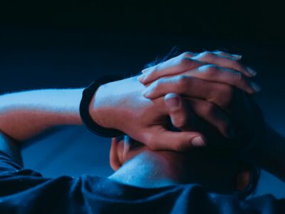 Social-anxiety, Close-up of a person in handcuffs with hands behind head, Social-anxiety, Social-anxiety